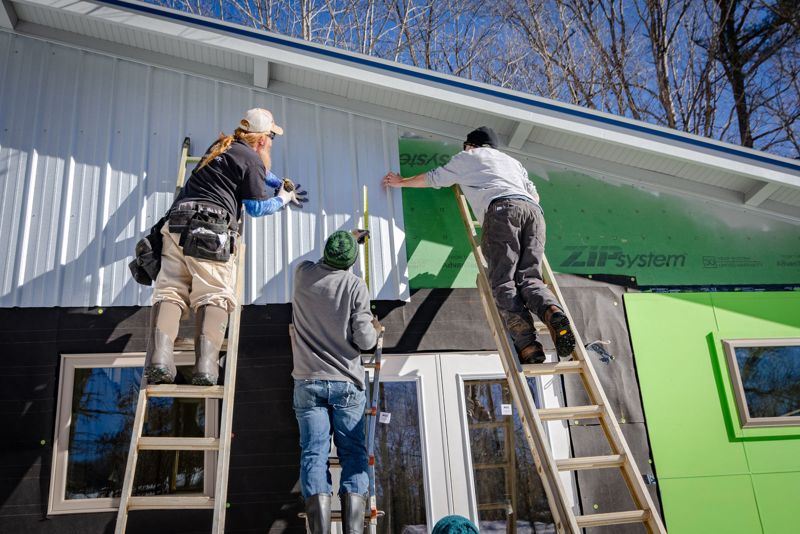 Exterior crew installing siding on a home